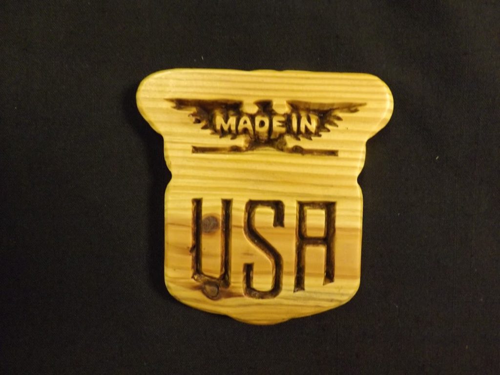 Wooden plaque on a black background with "MADE IN USA" engraved in a stylized font.